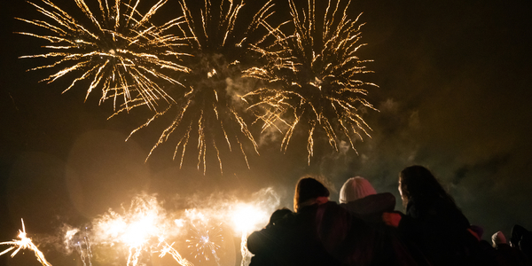 Meisjes kijken arm in arm naar het vuurwerk